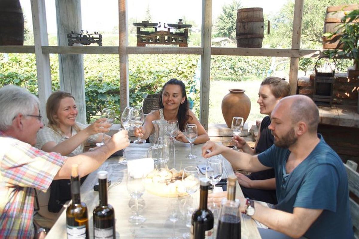 un gruppo di persone sedute attorno a un tavolo con bicchieri di vino
