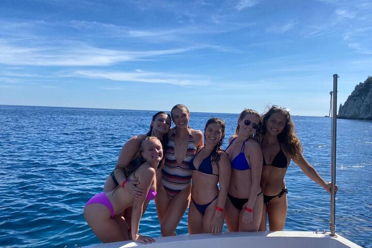 a group of women in bikinis posing on a boat