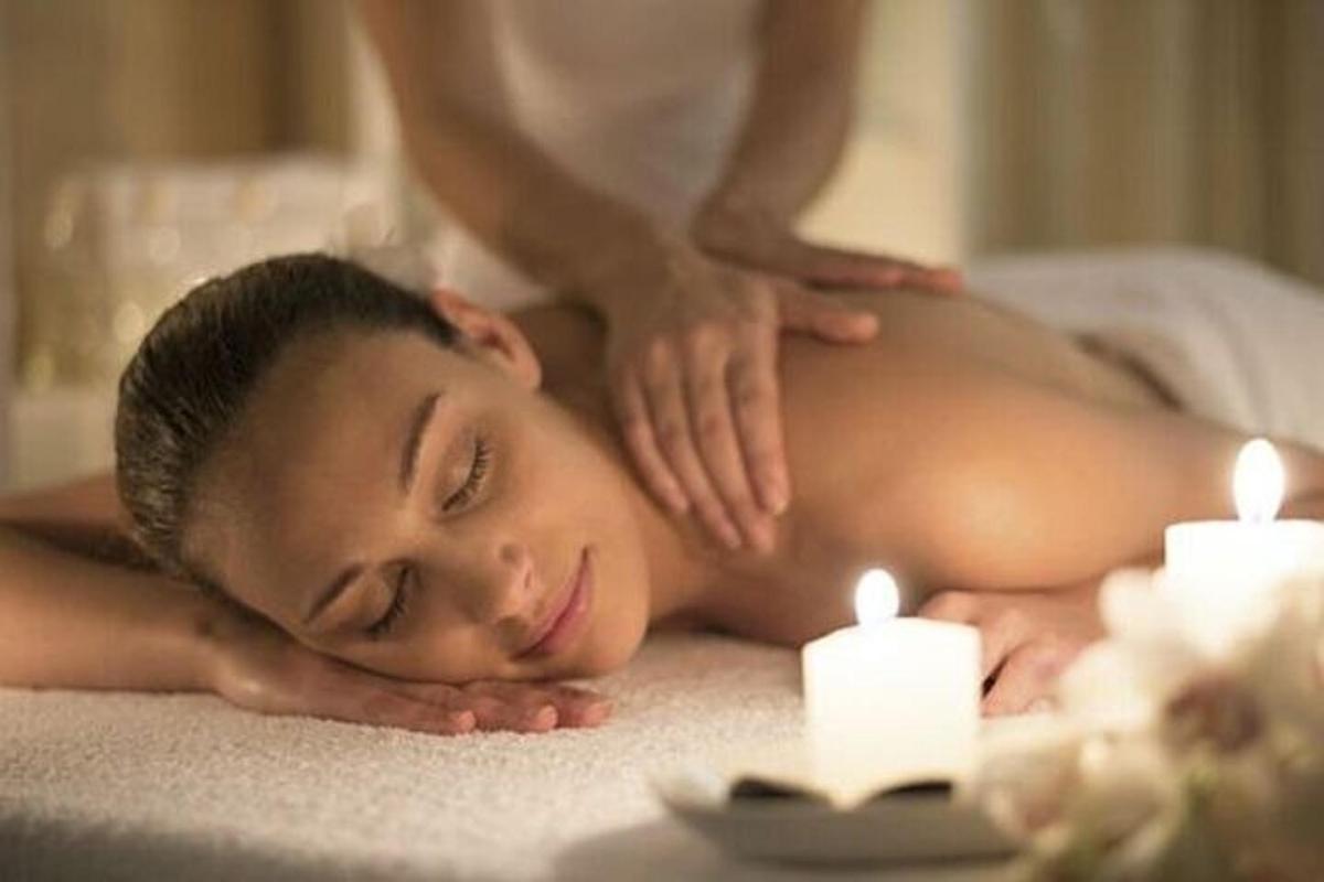 muškarac na masaži u spa centru sa svijećama