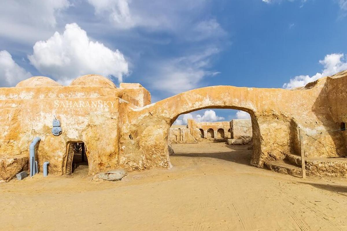 an ancient building with an arch in the desert