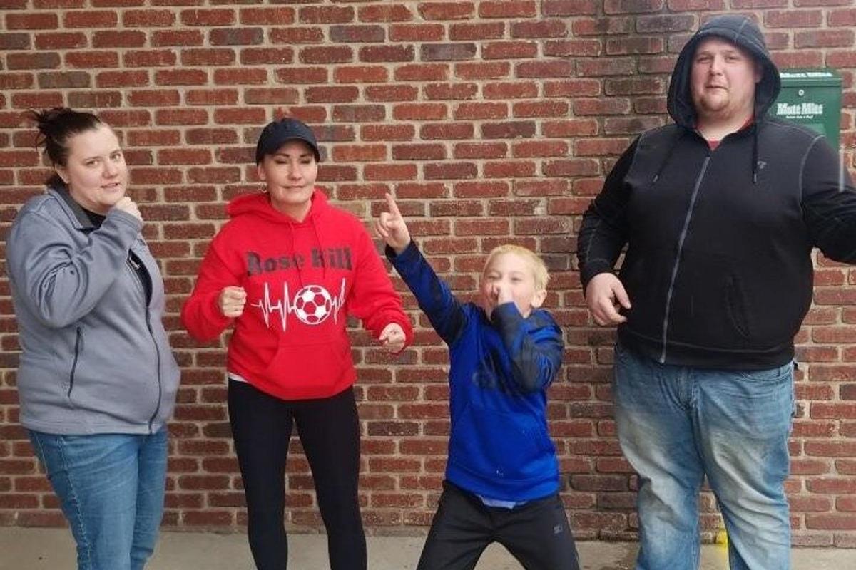 a group of people standing in front of a brick wall