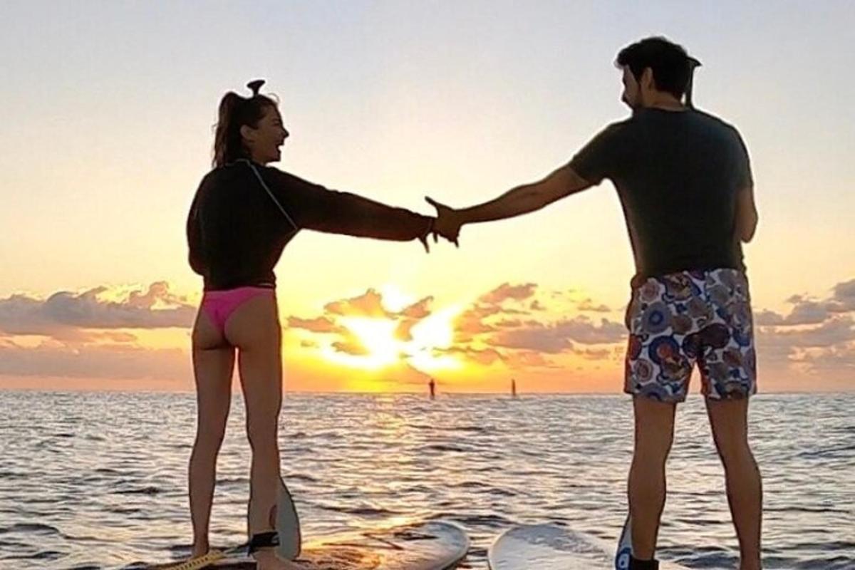 Un hombre y una mujer de pie en una playa con el océano.