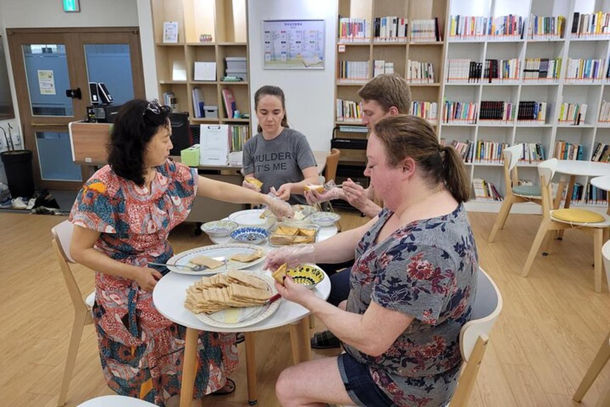 un gruppo di persone sedute attorno a un tavolo che mangiano cibo