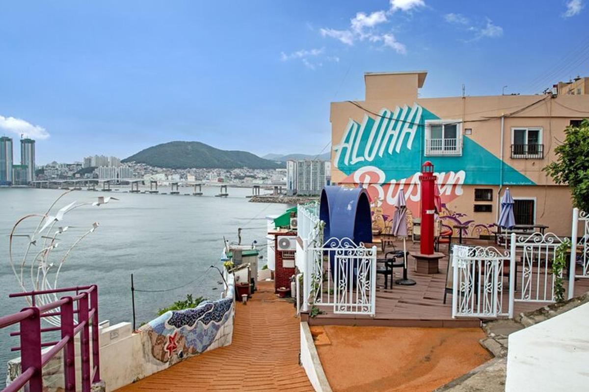 a deck with tables and chairs next to the water