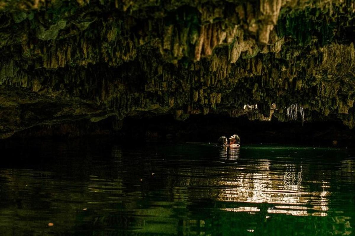 Un par de personas paradas en el agua en una cueva.