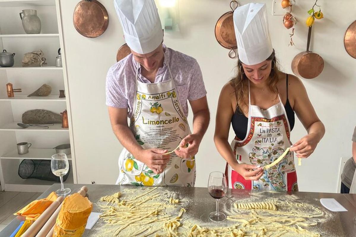 due persone con cappelli da chef che preparano il cibo in una cucina
