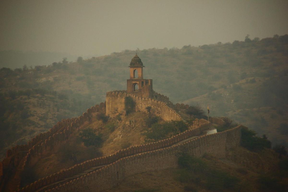 a building on top of a mountain with a wall