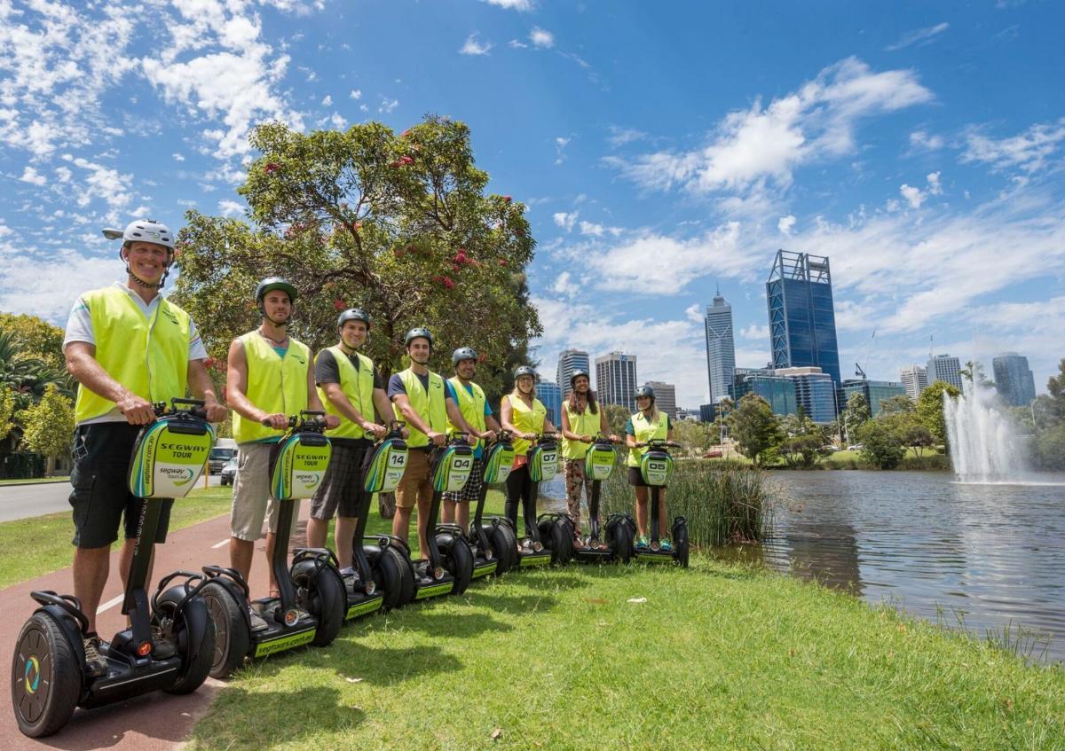 Un grupo de personas con camisetas amarillas viajan en segways.