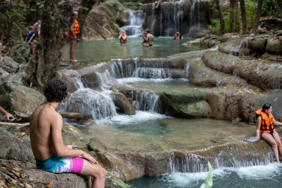 een groep mensen die voor een waterval zitten