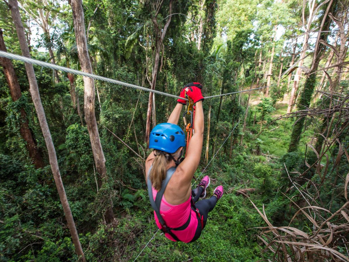 a woman on a zip line in the forest