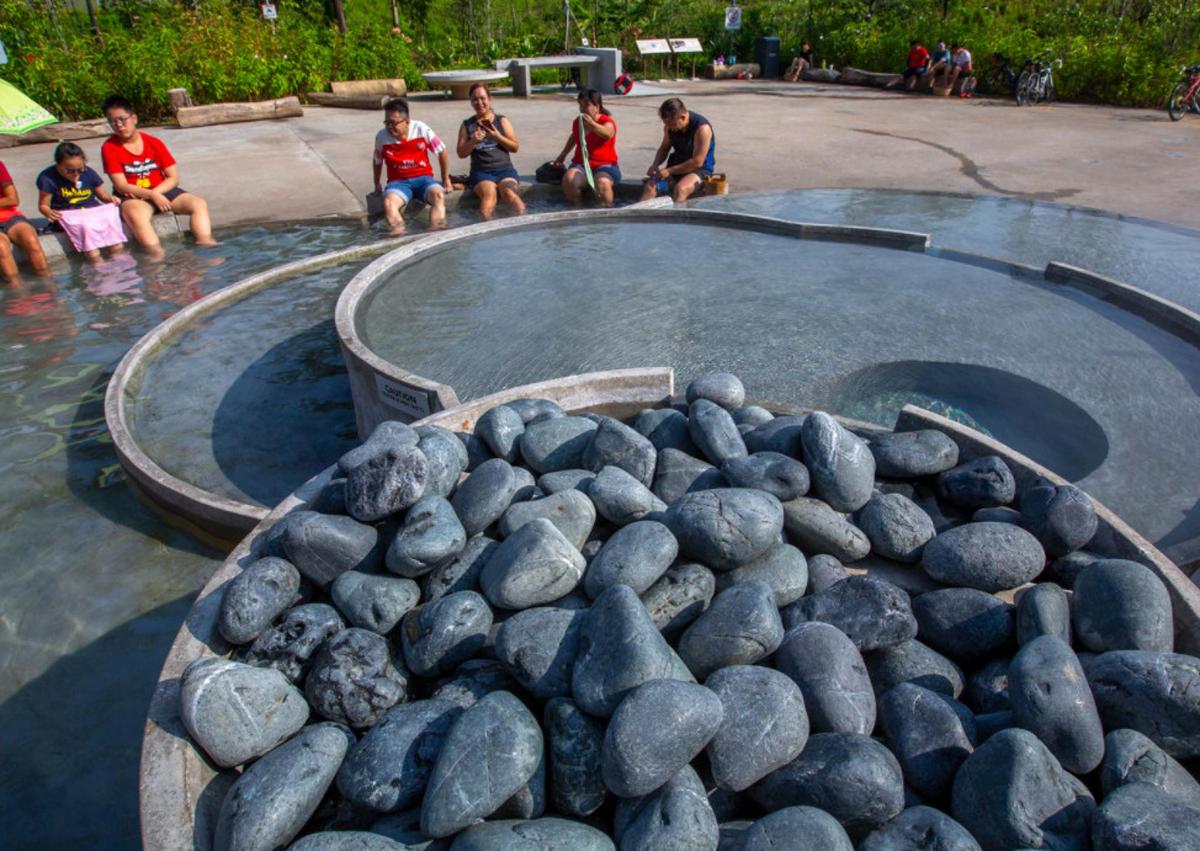 un grup de copii care stau într-o piscină cu apă și pietre