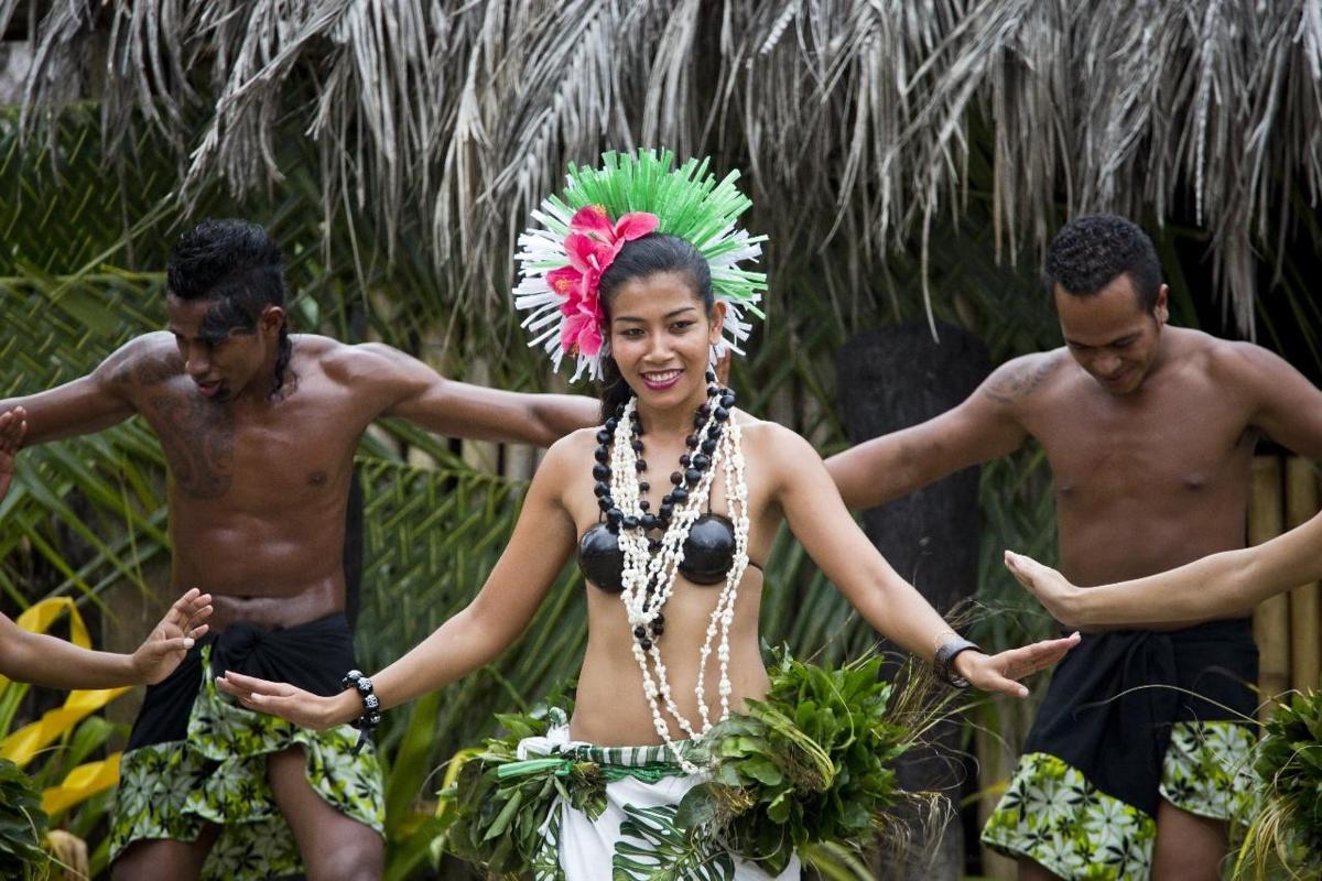 a woman in a native costume with two men