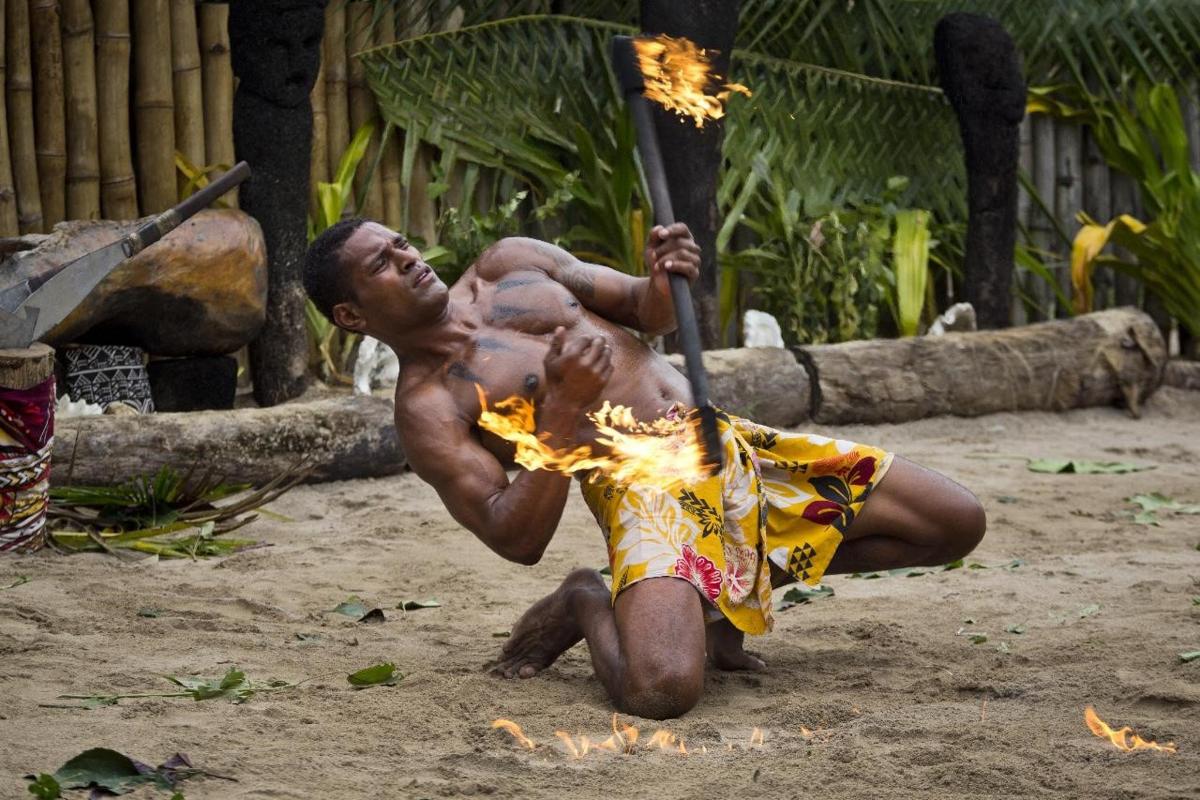 a man holding a baseball bat with fire on it