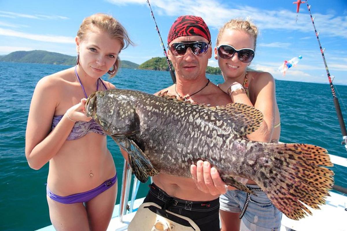 en mand og to kvinder på en båd med en fisk