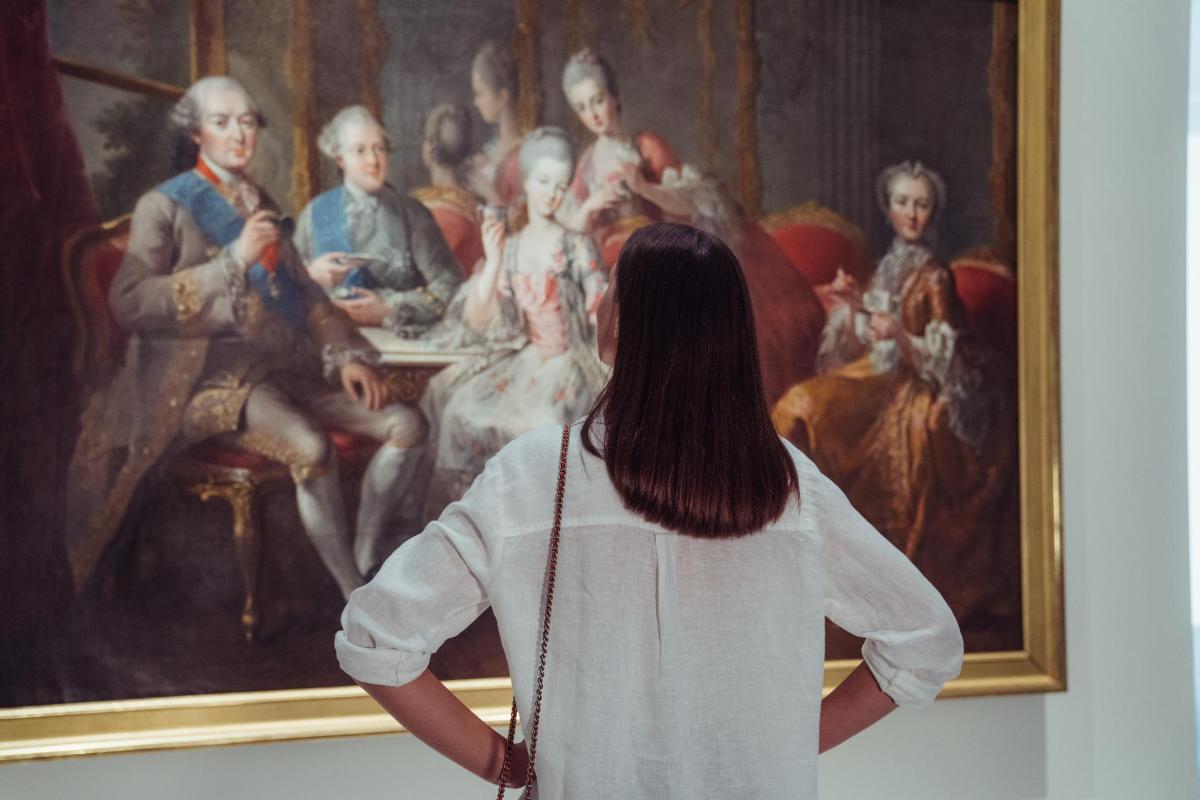 una donna che guarda un dipinto in un museo