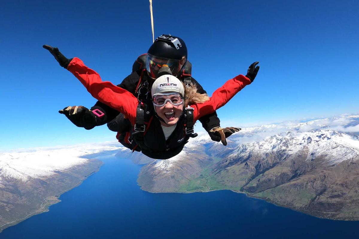 due persone stanno volando nel cielo sopra l'acqua