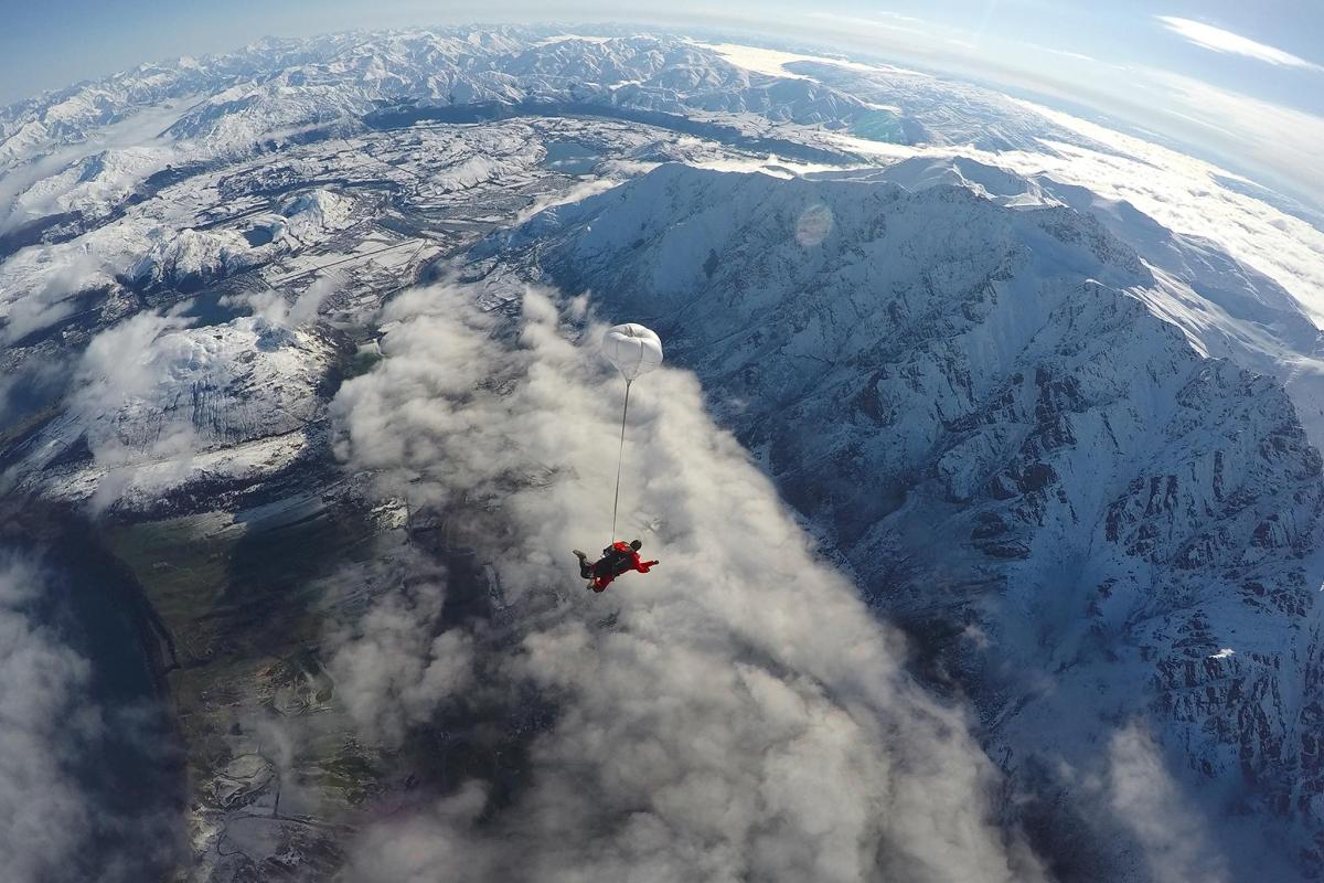 una persona è appesa a un paracadute sopra una montagna