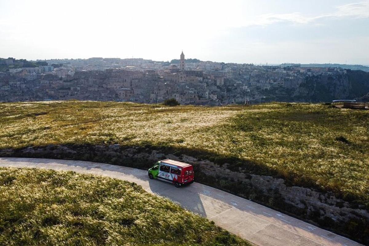 a red van driving down a road on a hill