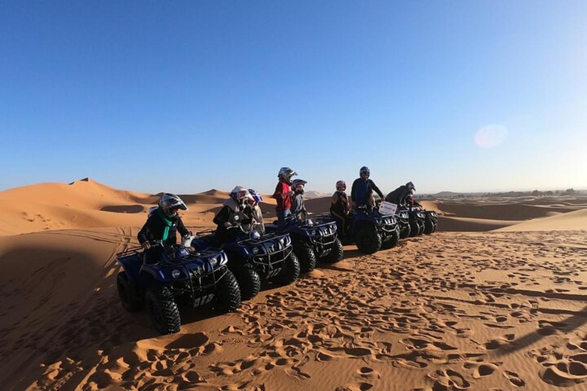sekelompok orang mengendarai ATV di padang pasir