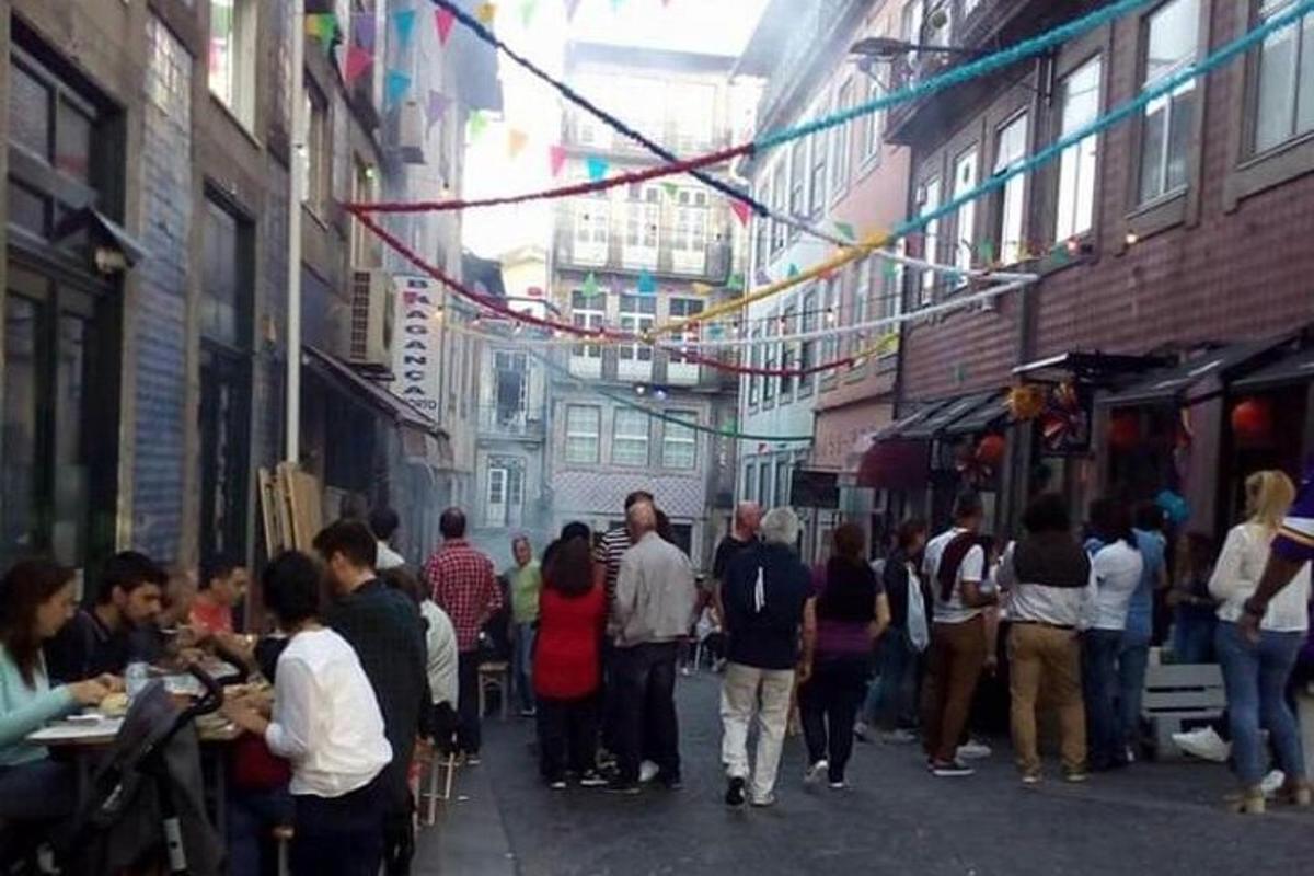 un gruppo di persone che camminano lungo una strada con venditori di cibo
