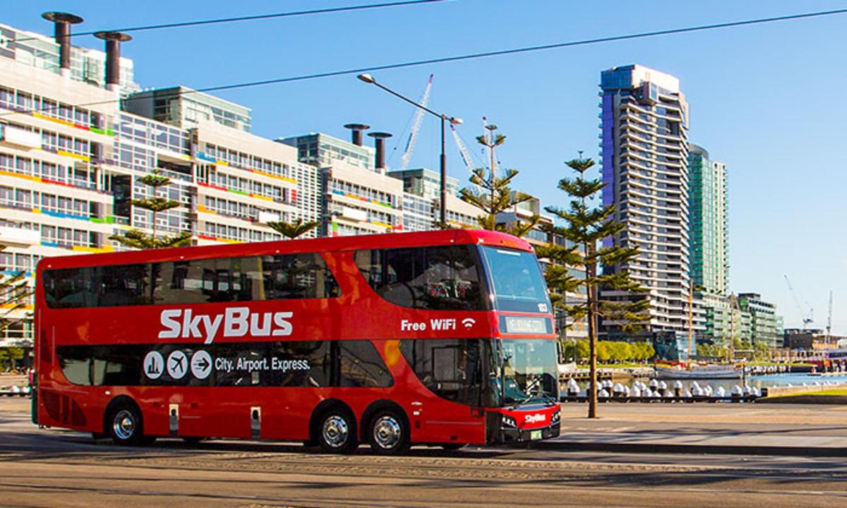 a red double decker bus driving down a street