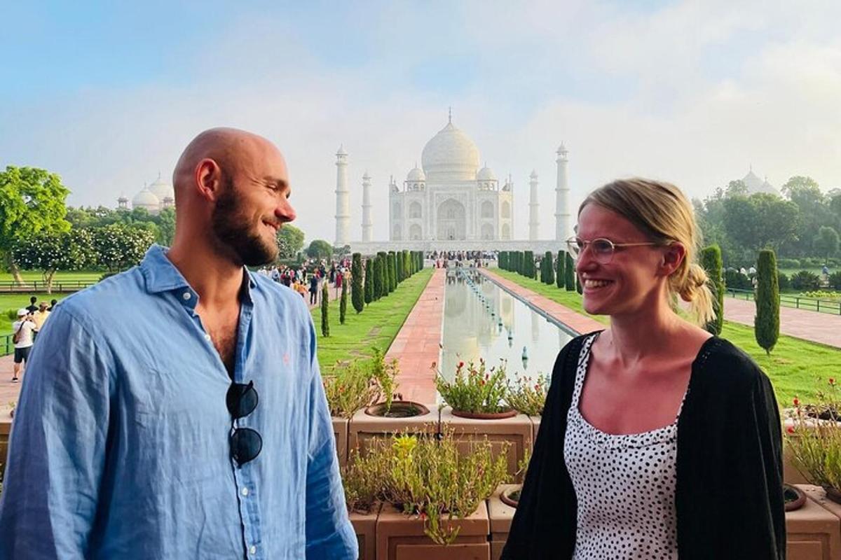 a man and a woman standing in front of the taj mahal