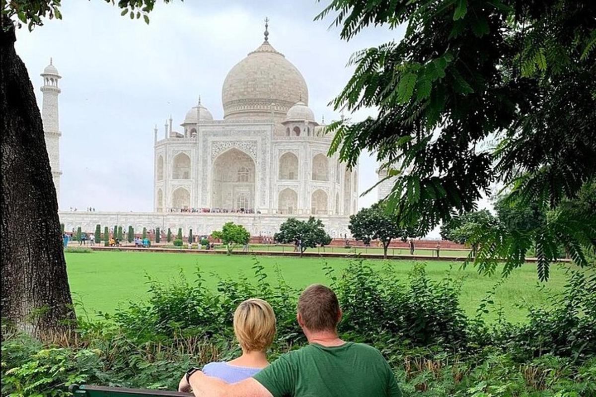 a man and woman sitting on a bench in front of a building