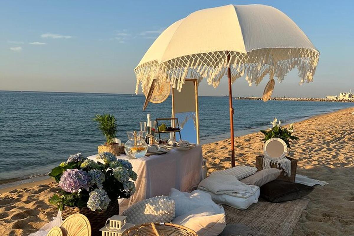 uma mesa na praia sob um guarda-sol