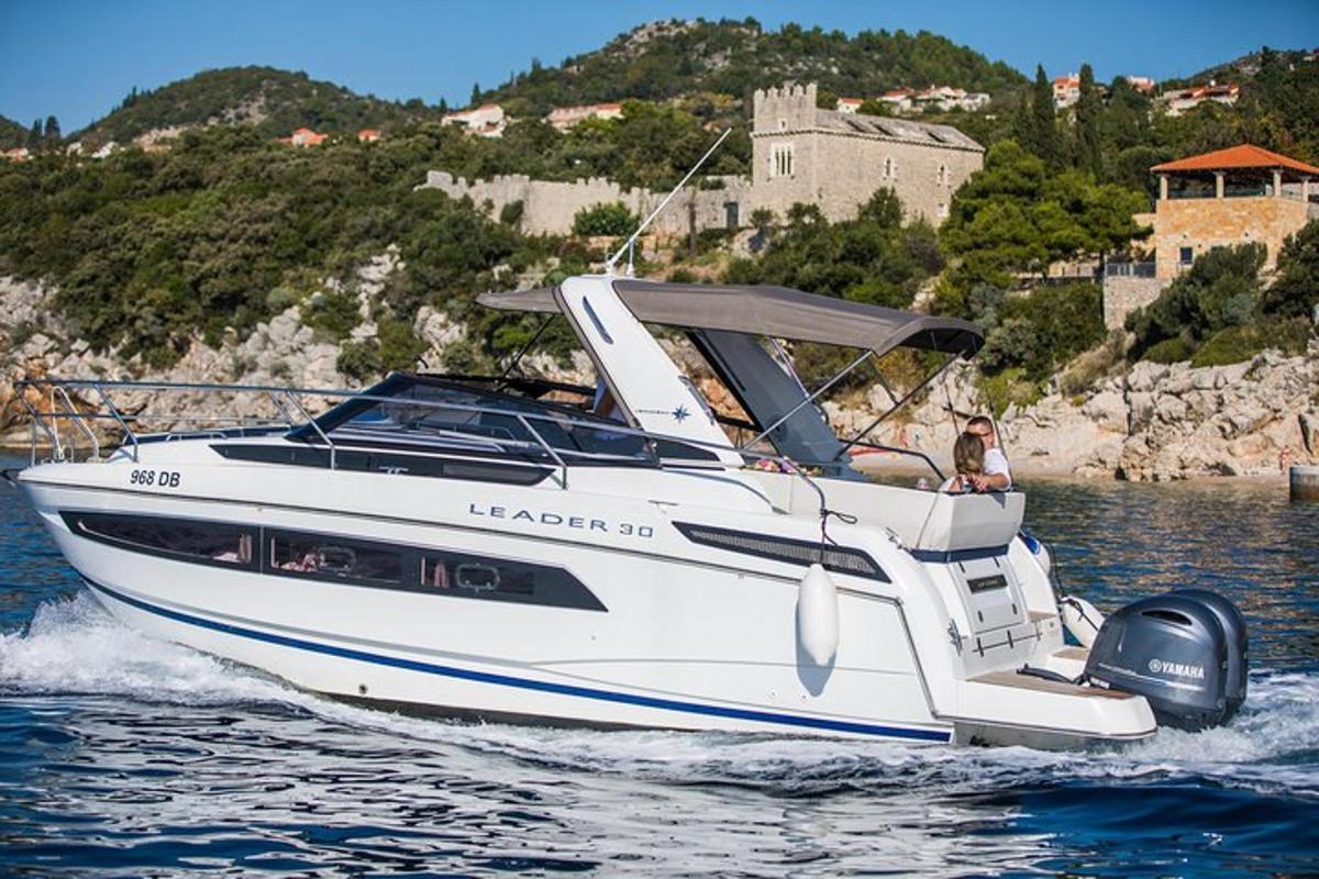 una barca bianca sull'acqua con un castello sullo sfondo