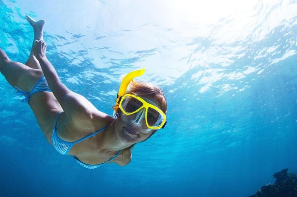 una donna in costume da bagno e occhialini che nuota nell'acqua