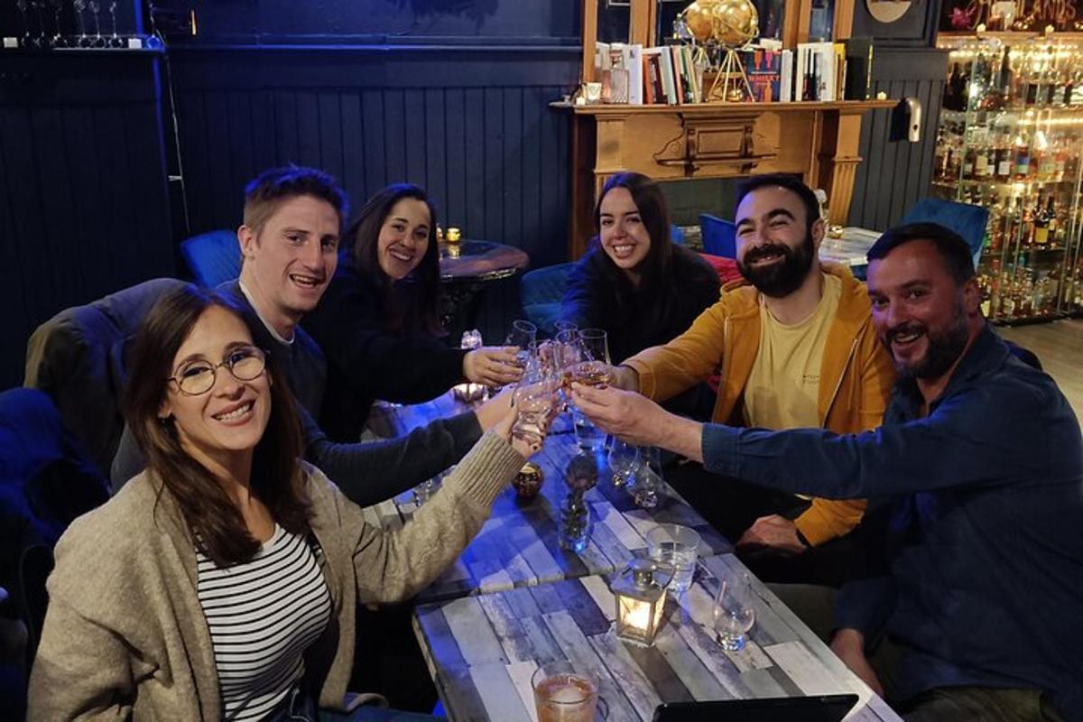 un grup de oameni așezați în jurul unei mese cu pahare