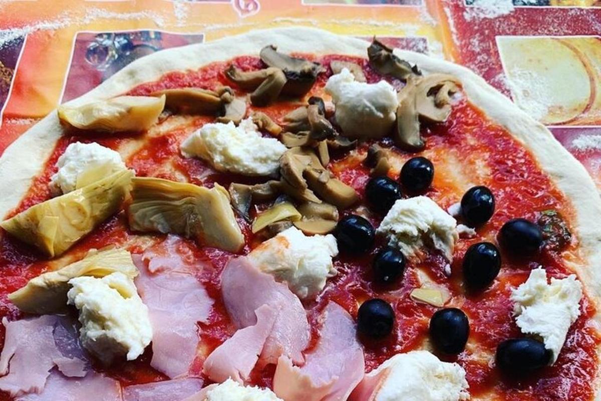 uma pizza com queijo e azeitonas em uma mesa