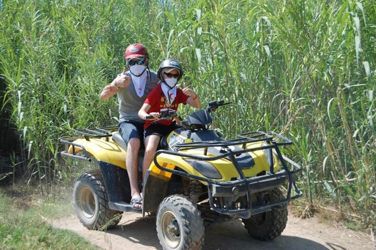 Un hombre y una mujer viajando en un vehículo de cuatro ruedas