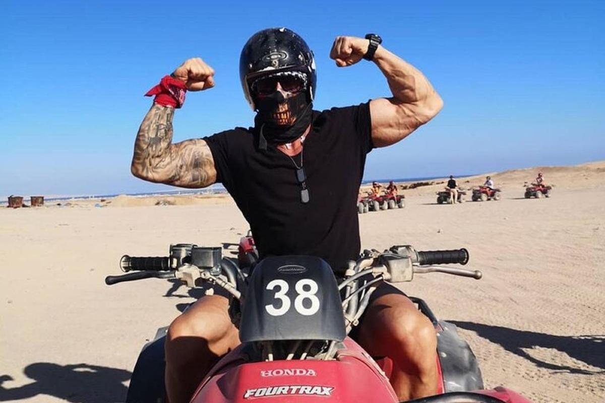 um homem andando de moto na praia