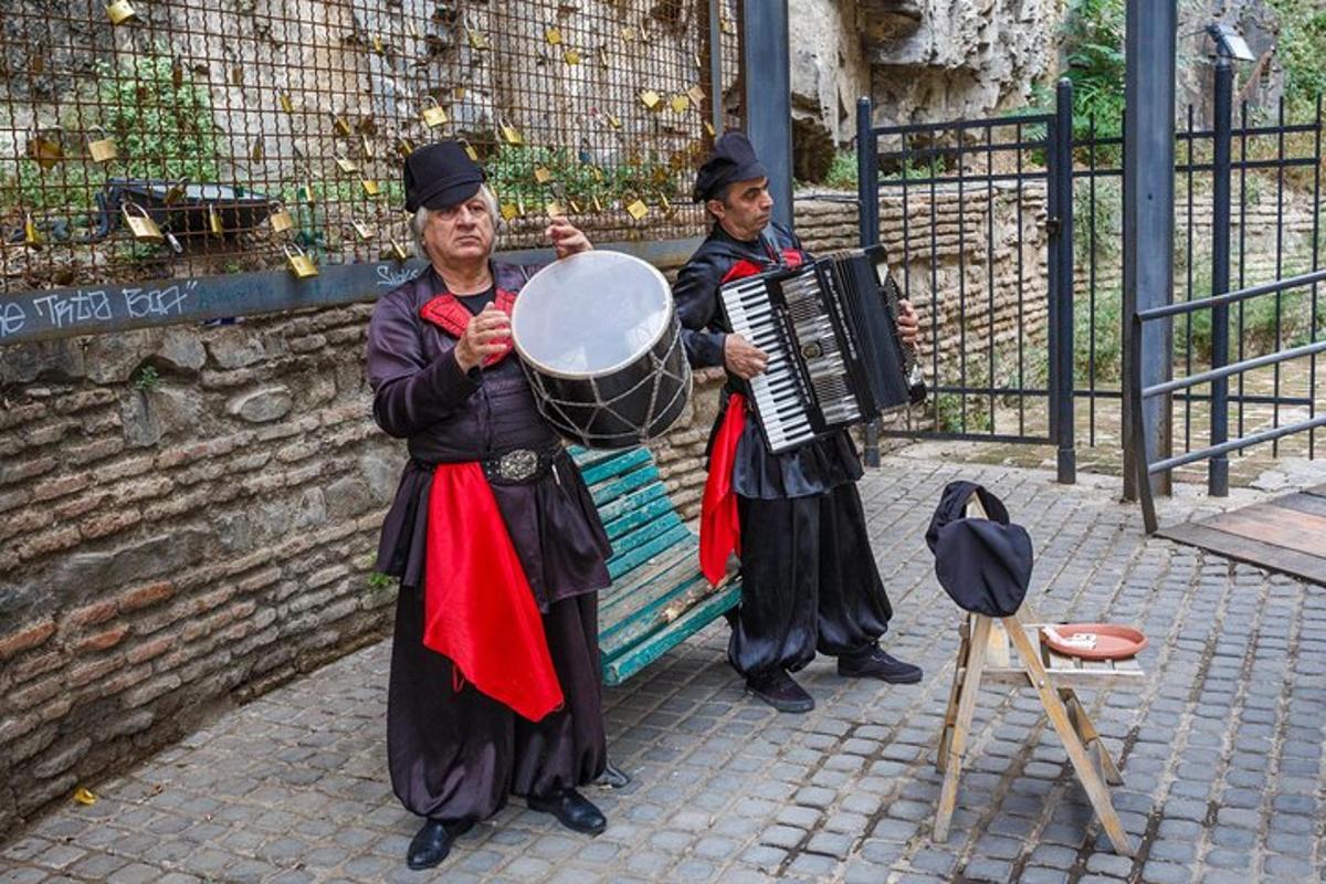 dva muži v kostýmech hrající na hudební nástroje na ulici