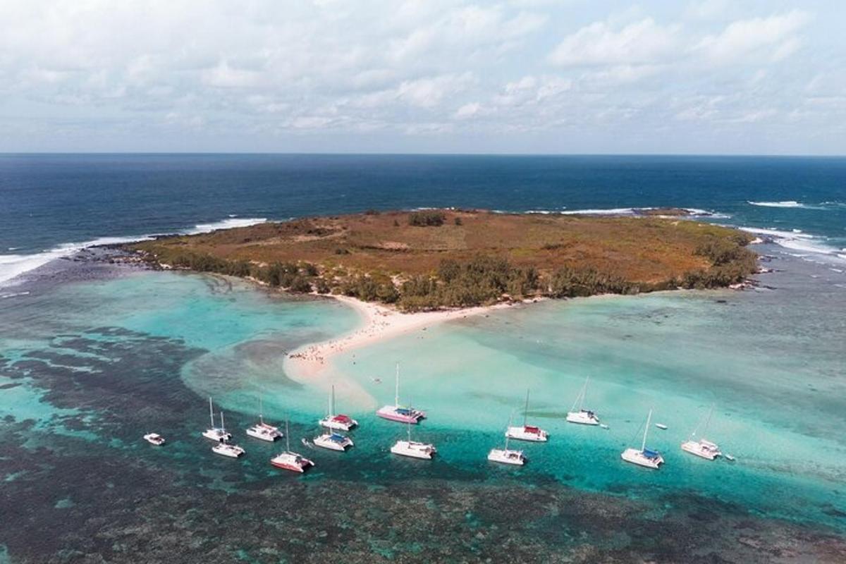 sebuah pulau kecil dengan bot di dalam air