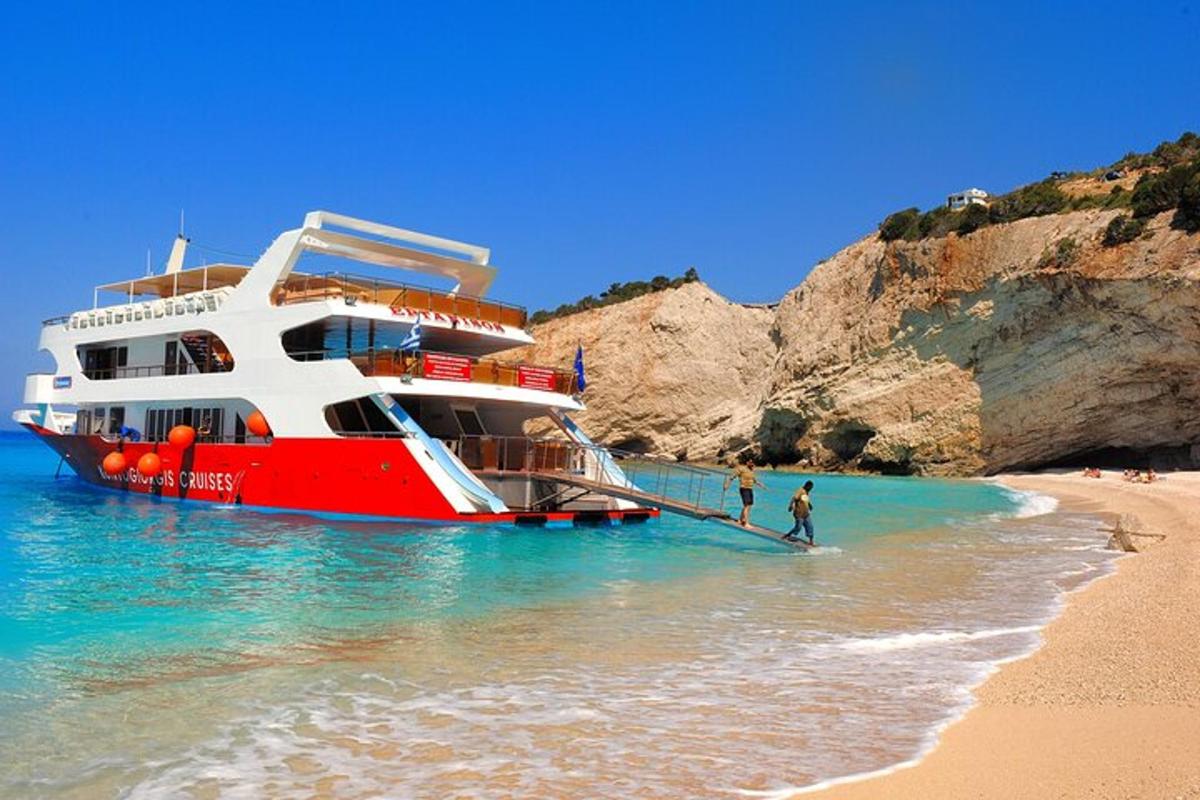 a red and white boat in the water on a beach