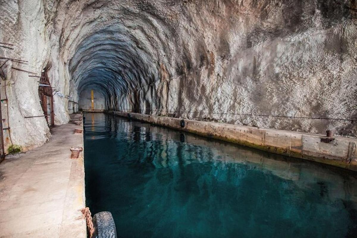 Un túnel con un estanque de agua en una cueva.
