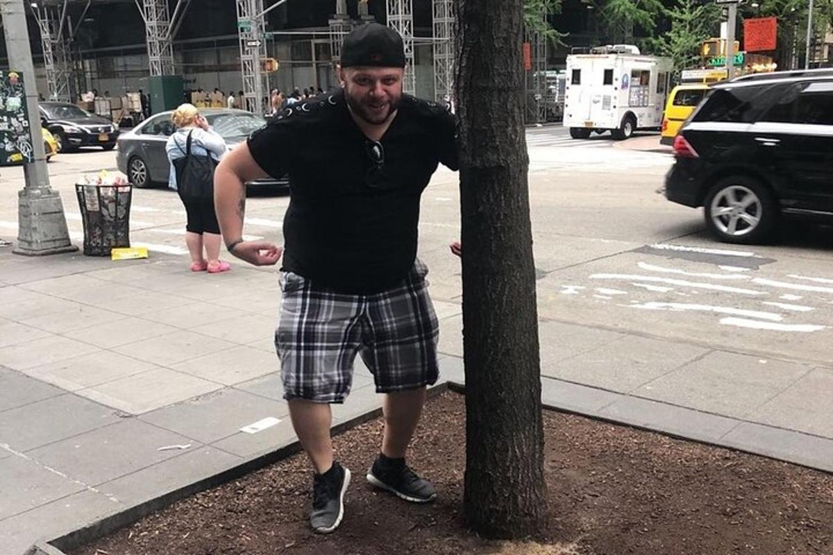 a man is standing next to a tree