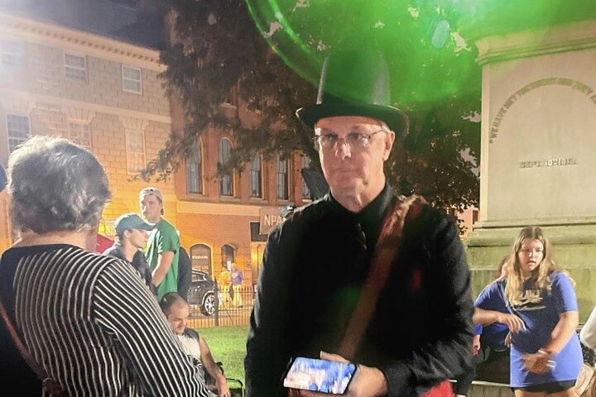 a man wearing a green top hat and glasses