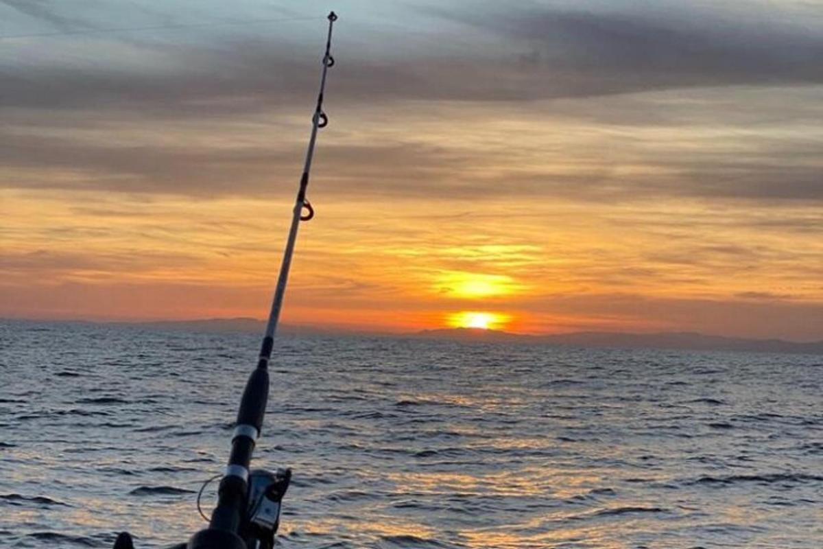 seseorang yang memegang pancing di laut