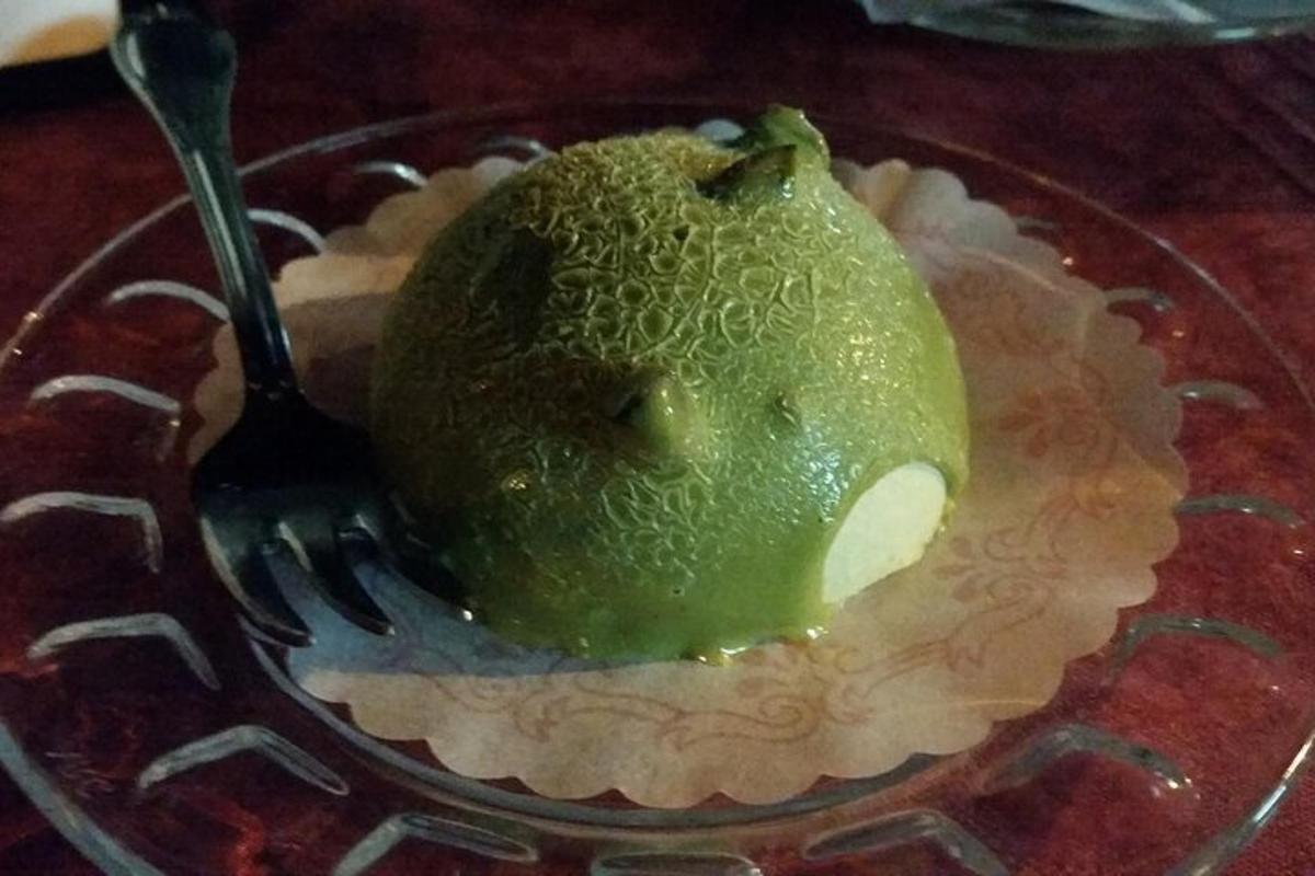 una pera verde in una ciotola di vetro con una forchetta