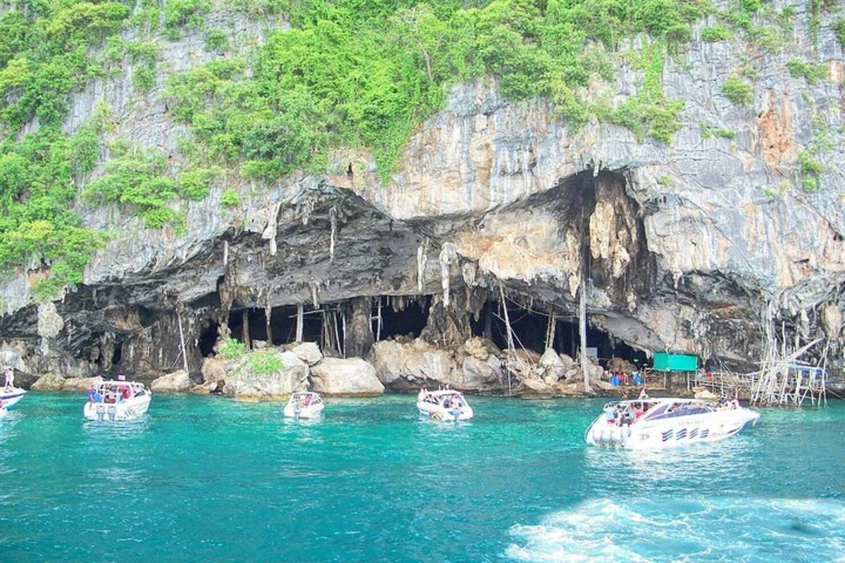 a group of boats in the water in front of a cave