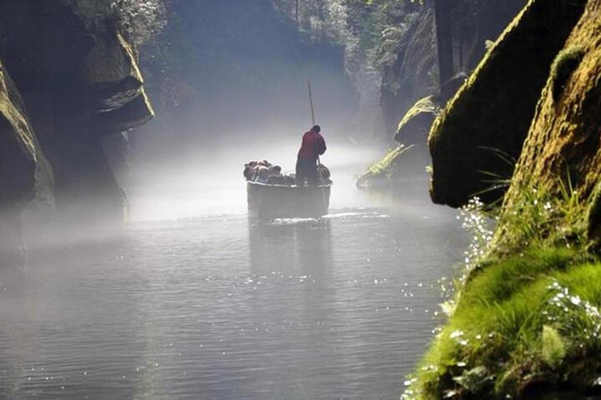 seorang pria berdiri di atas perahu di sungai