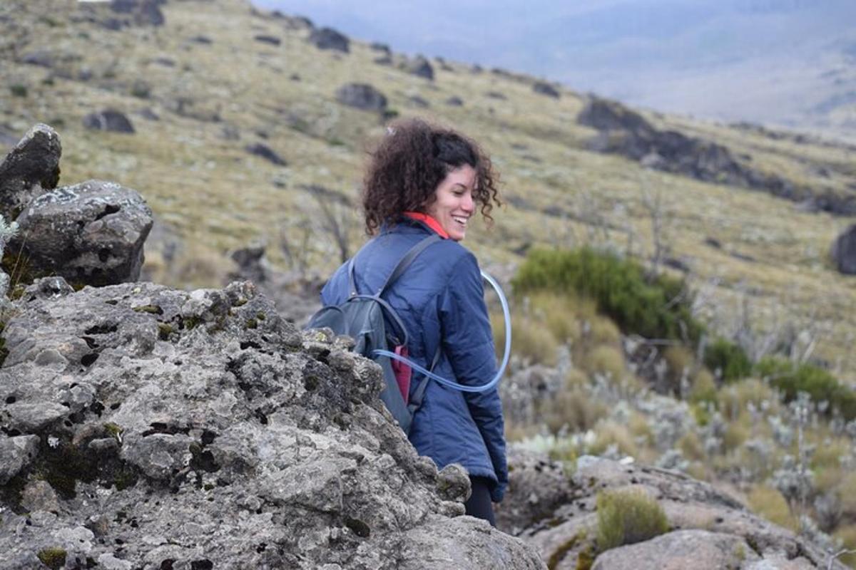 seorang wanita berdiri di atas gunung berbatu