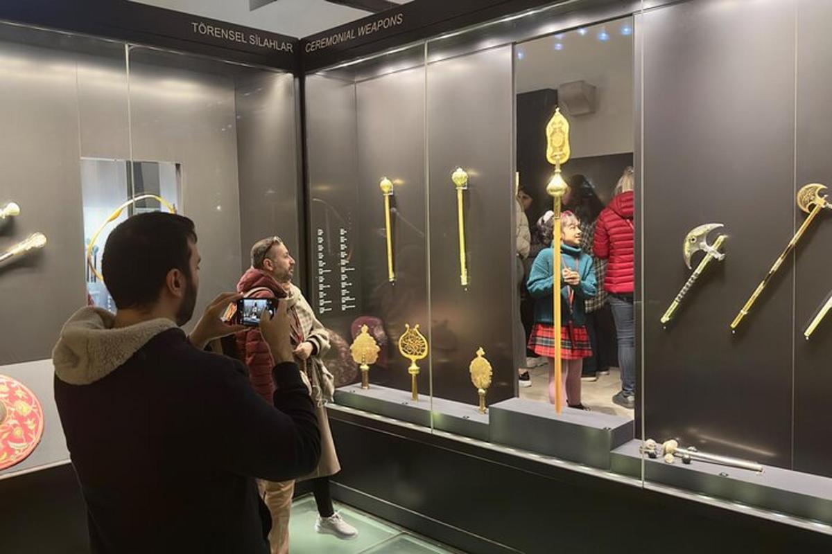 un uomo che scatta una foto di una mostra di oggetti d'oro