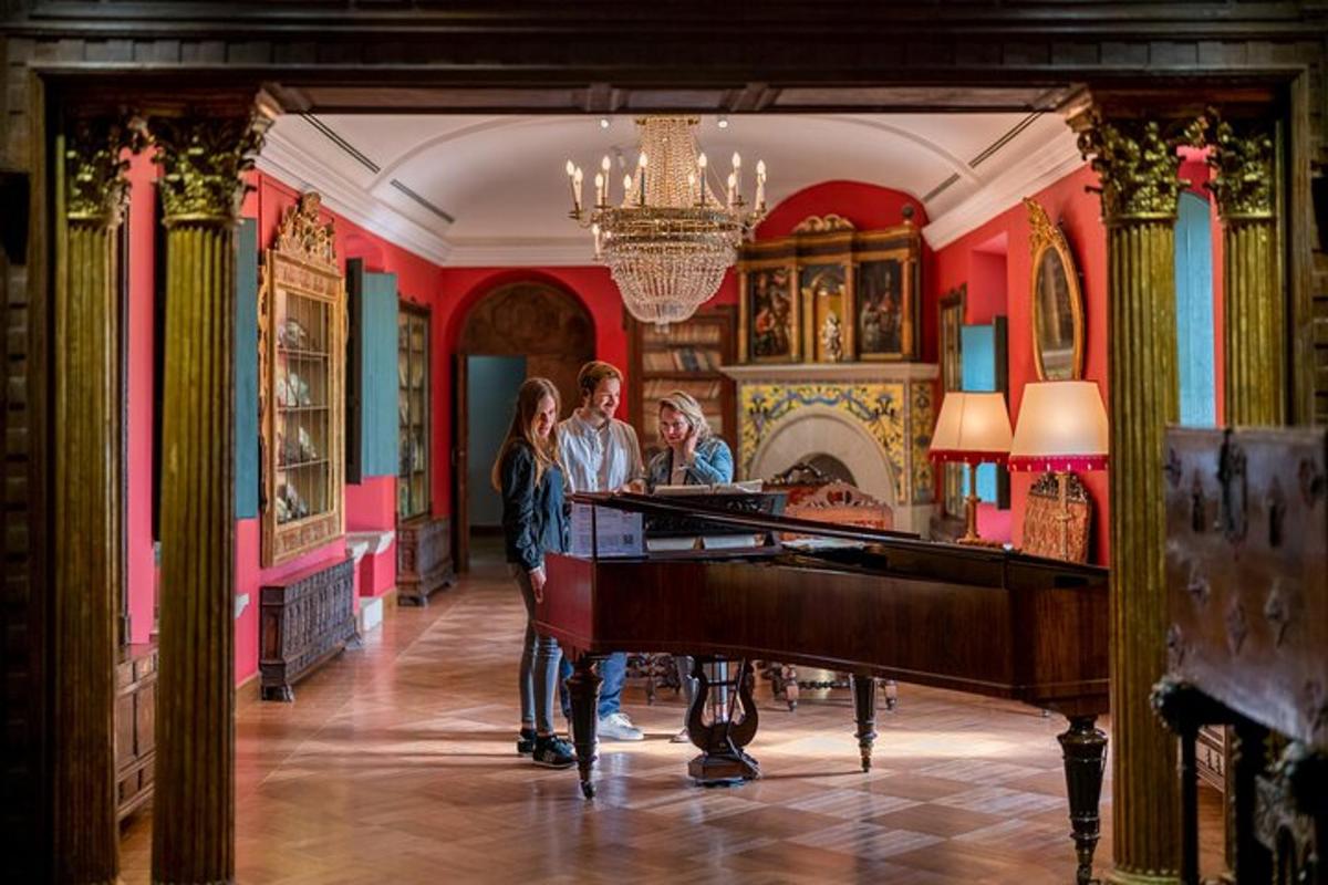 um grupo de pessoas em pé em uma sala com um piano