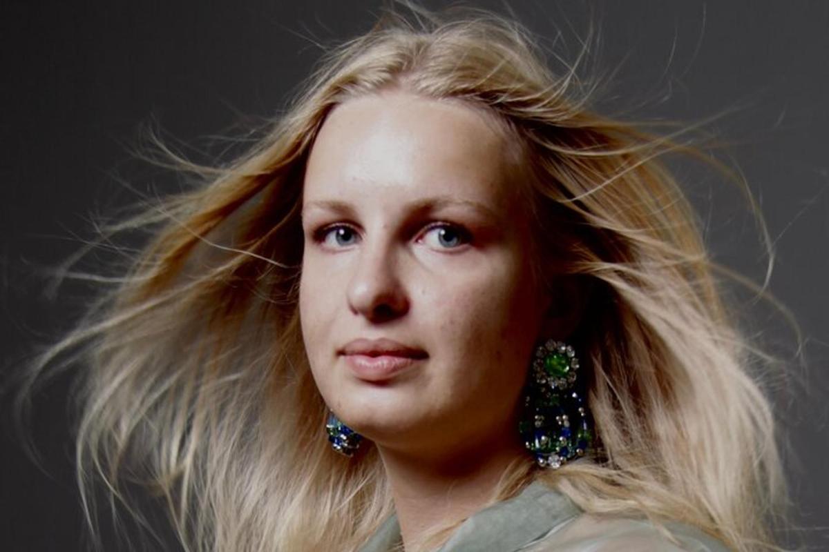 una giovane donna con lunghi capelli biondi e orecchini