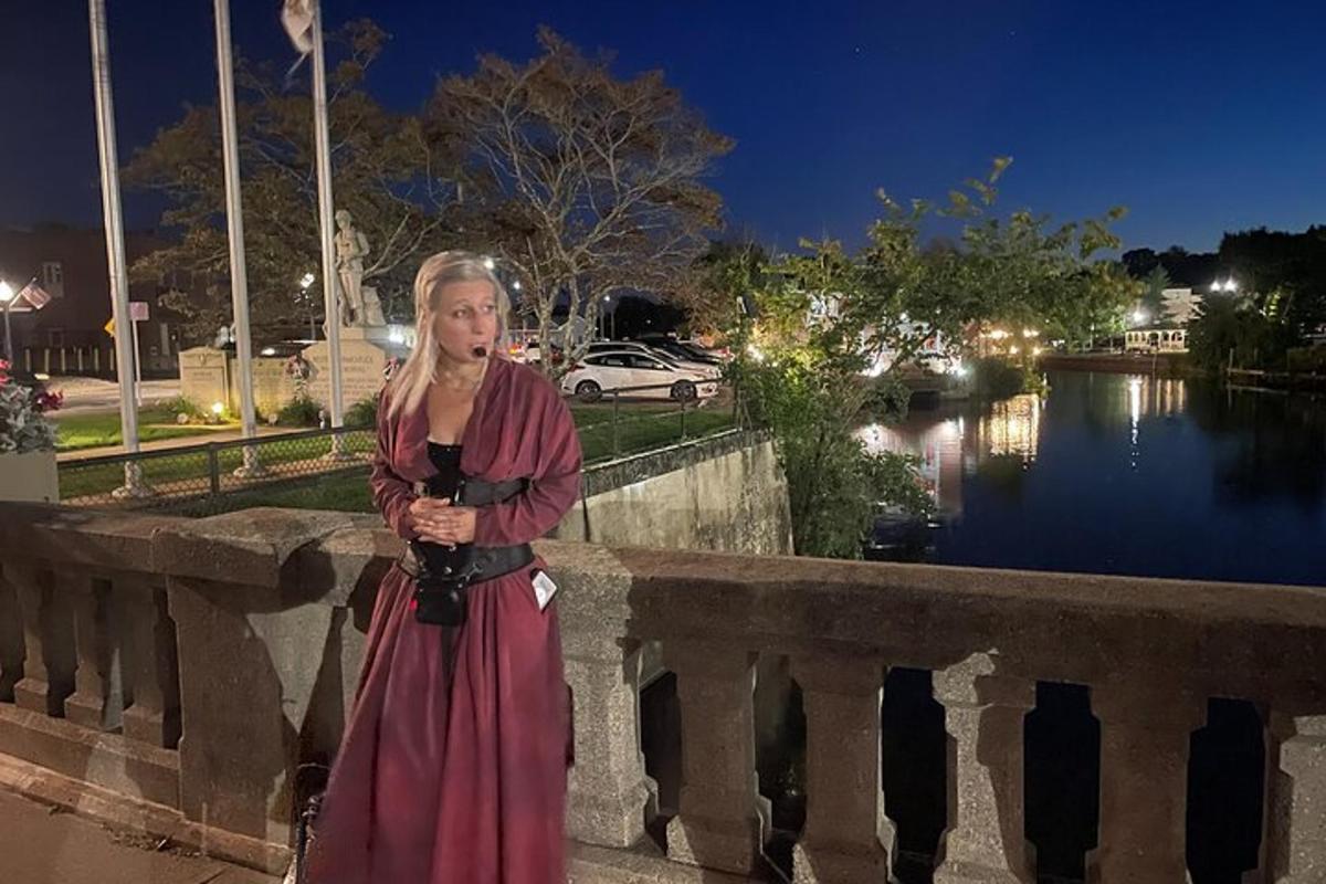 a woman in a dress standing on a bridge