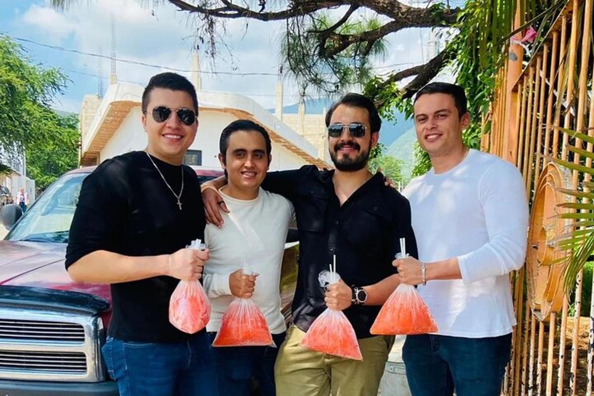 un grup de trei bărbați care țin saci cu mâncare